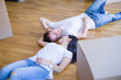 © Krakenimages.com - Young beautiful couple lying down at new home around cardboard boxes