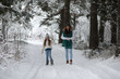 © alexkich - Young family for a walk. Mom and daughter are walking in a winter park.