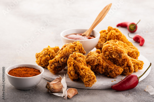 Fotomural Spicy chicken wings breaded with spices and ketchup on the table.
