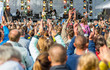 © pavel siamionov - many different people at a concert listening to rock band music open air