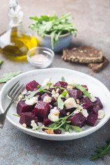 Poster - beetroot salad with blue cheese, arugula and walnut in a white plate on gray background