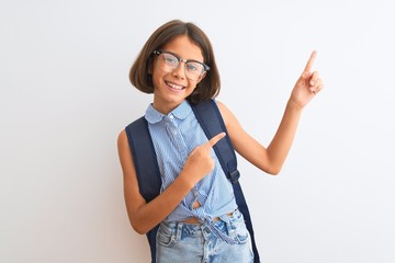 Sticker - Beautiful student child girl wearing backpack and glasses over isolated white background smiling and looking at the camera pointing with two hands and fingers to the side.