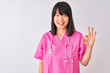 © Krakenimages.com - Young beautiful Chinese nurse woman wearing stethoscope over isolated white background showing and pointing up with fingers number three while smiling confident and happy.