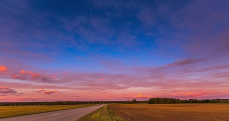 Wall Mural - Red sunset sky time lapse with a road. Clouds timelapse nature background. Dramatic evening color beauty. Twilight, dusk dawn, summer.