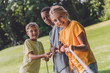 © LIGHTFIELD STUDIOS - selective focus of happy multicultural kids competing in tug of war