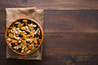 Healthy trail mix snack made of nuts (walnut, almond, peanut) and dried fruits (raisin, sultana) in wooden bowl, photographed overhead with copy space on the right side