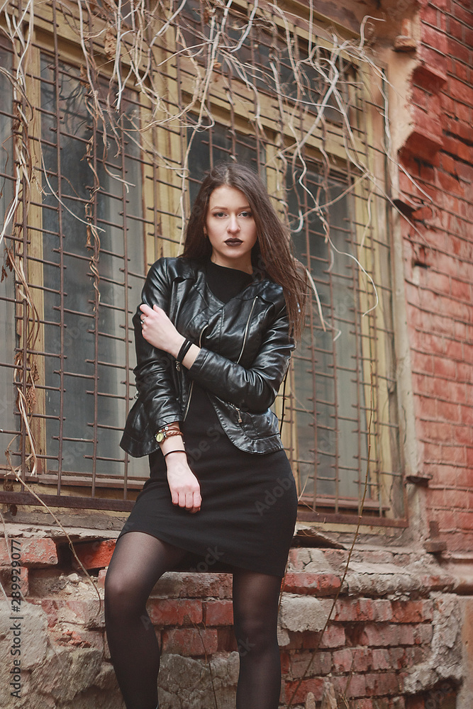 Woman wear on a leather jacket, black dress and tights in grunge gothic  style outdoors Stock Photo | Adobe Stock