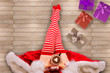 © michelaubryphoto - Girl wearing red and white socks, sits on a white wooden floor. Directly above. Cozy Christmas Holidays concept.