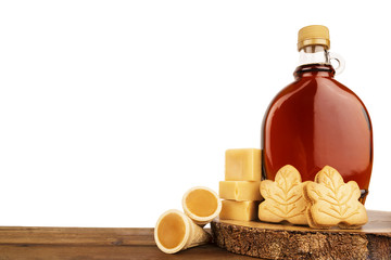 maple syrup bottle and maple products on a wooden plank. copy space for your text. cut out.