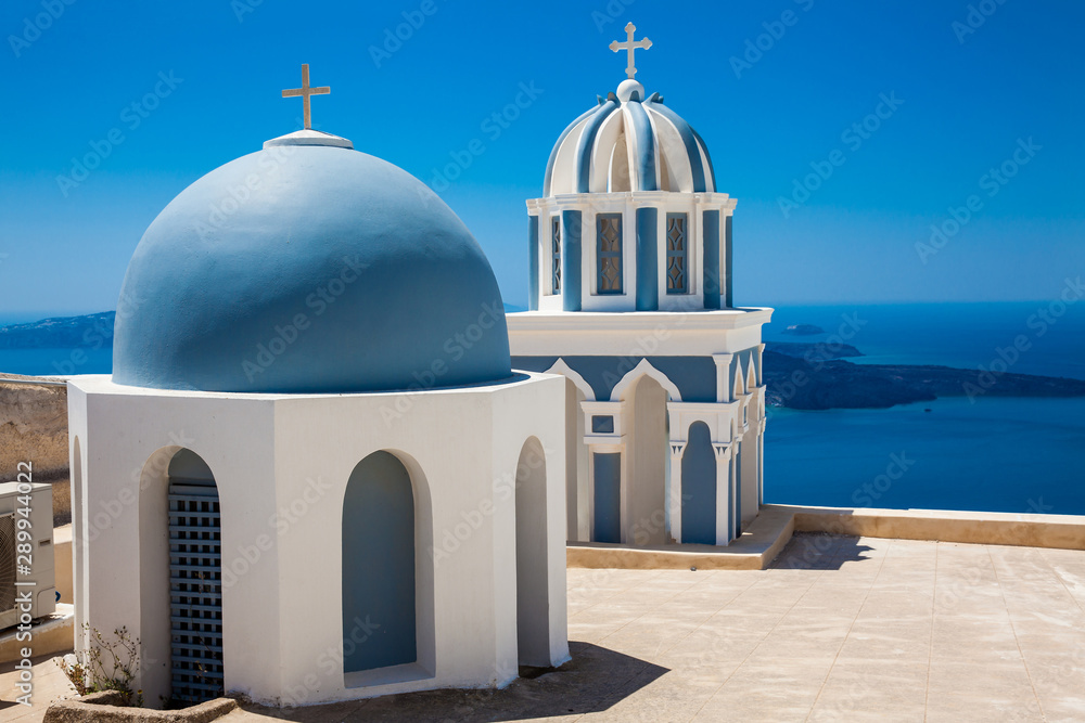 Domes on the rooftop of the Church of St. Mark the Evangelist and the Aegean Sea on the Fira City at Santorini Island - obrazy, fototapety, plakaty 