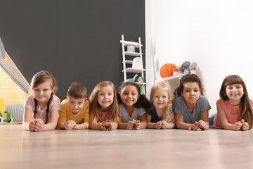 Sticker - Cute little children lying on floor in kindergarten. Indoor activity