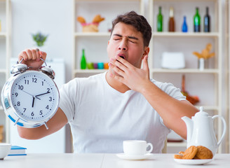 Canvas Print - Man with alarm clock falling asleep at breakfast