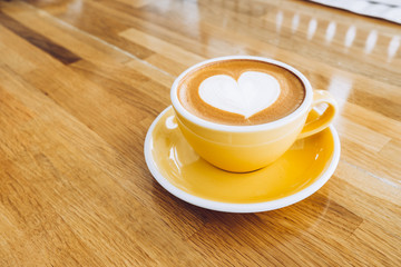 Wall Mural - hot cappuccino coffee cup on wooden tray with heart latte art on wood table at cafe,Banner size food and drink concept.