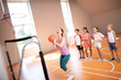© zinkevych - Red-haired PE teacher throwing ball into basket