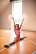 © zinkevych - Positive dark-skinned cheerleader doing leg split