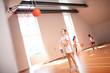 © zinkevych - Slim girl wearing white shorts trying to throw ball into basket