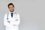 Fototapeta Do pokoju - Smiling doctor standing on grey background