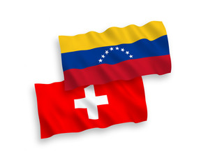 National vector fabric wave flags of Venezuela and Switzerland isolated on white background. 1 to 2 proportion.