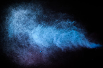 Wall Mural - freeze motion of colored dust explosion isolated on black background.