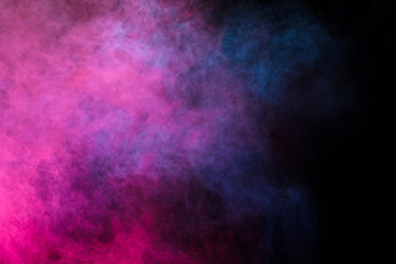 Wall Mural - freeze motion of colored dust explosion isolated on black background.