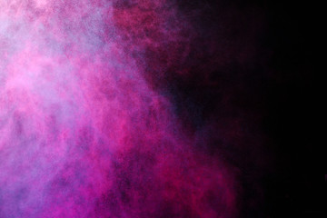 Wall Mural - freeze motion of colored dust explosion isolated on black background.