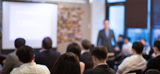 Fototapete - Business presentation being given by executive manager. Corporate seminar with expert speaker presenting to people. Presenter giving speech during lecture. Leadership training coach in workshop.