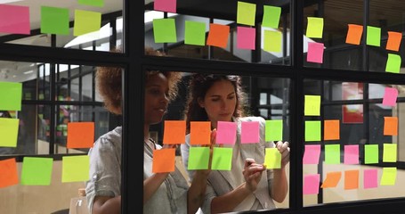 Wall Mural - happy diverse female colleagues team write on stickers in office