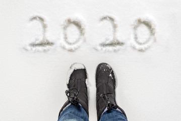 Wall Mural - 2020 written in the snow with selfie of boots, winter new year greeting card