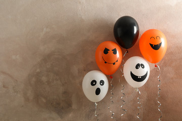 Different balloons on brown background. Halloween concept, space for text