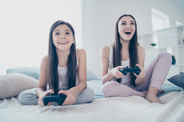 Poster - Portrait of two nice-looking beautiful attractive lovely charming cute cheerful cheery glad long haired positive people playing playstation battle amusement in light white interior room indoors