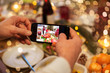 © Syda Productions - food, technology and holidays concept - close up of male hands photographing roast turkey by smartphone at christmas dinner