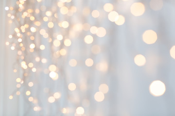 Wall Mural - holiday, illumination and decoration concept - bokeh of christmas garland lights over grey background