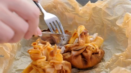 Wall Mural - Woman is eating julienne baked in dough served on a plate on baker paper with tea and butter