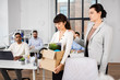 © Syda Productions - business, firing and job loss concept - colleague seeing off sad fired asian female office worker holding box of his personal stuff