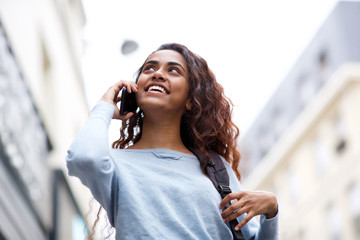 Wall Mural - happy young woman talking with cellphone in the city