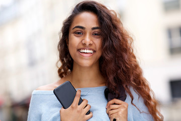 Wall Mural - front portrait of beautiful young Indian woman smiling with mobile phone