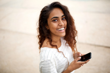 Wall Mural - side portrait of attractive young indian woman with cellphone