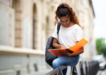 Wall Mural - female university student sitting outside on campus