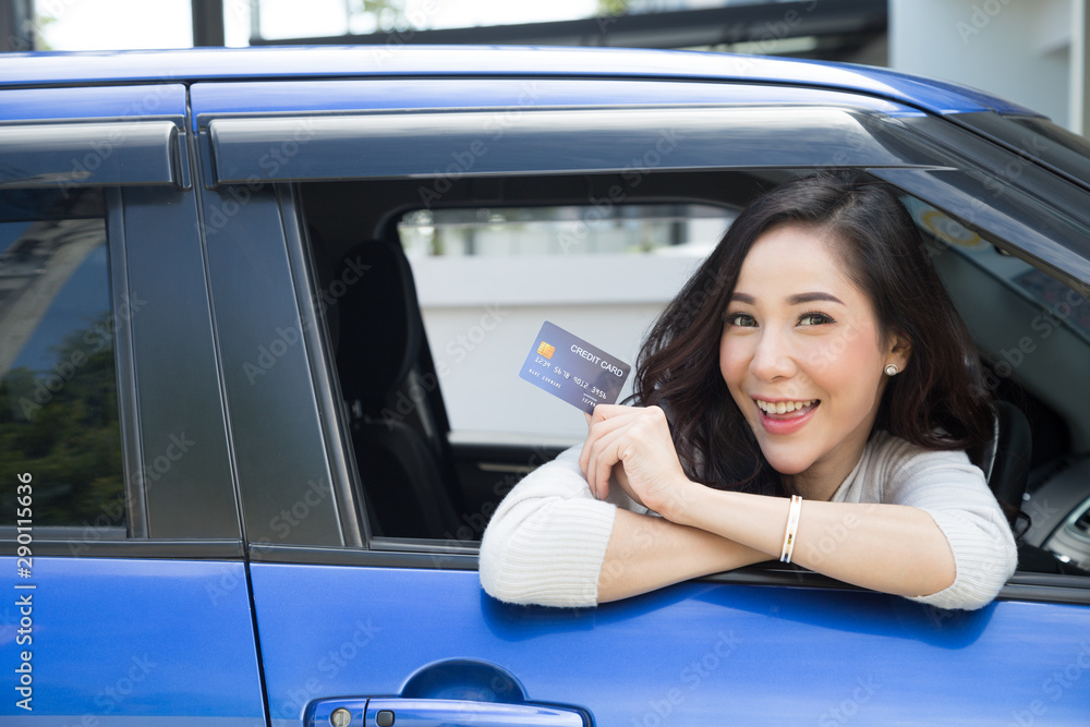 Happy young Asian woman holding payment card or credit card and used to pay for gasoline, diesel, and other fuels at gas stations, Driver with fleet cards for refueling car - obrazy, fototapety, plakaty 