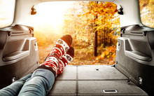 Woman Legs In Car Interior And Autumn Landscape Of Forest 