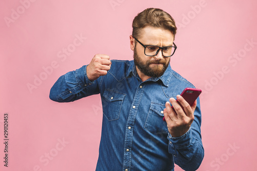 Fotografía Young caucasian man angry, frustrated and furious with his phone, angry with customer service