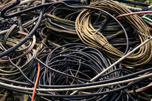 A Pile Of Old Metal Electrical Cables, Wires In A Tangled Pile, Waiting For Recycle, Use.