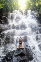 Canvas Print - Woman practices yoga near waterfall in Bali, Indonesia