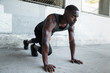 © elnariz - African american male athlete preparing for a jog, stretching, fitness and exercise in urban theme