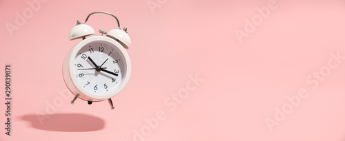 Fotomural Pink Alarm clock on pastel pink background.