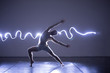 © qunica.com - Modern Dance performer dancing with a neon blue light while making gracious moves and spectacular body art expressions.