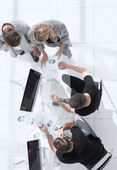 Wall Mural - Image from above of business people sitting around conference desk and consulting.