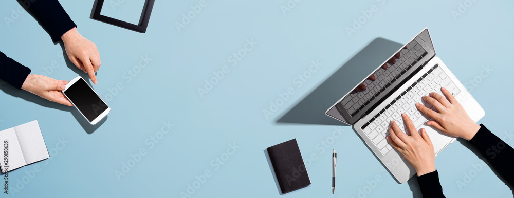 Two people working together with laptop and phone