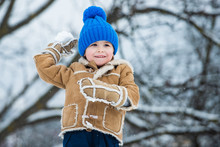 Making Snowball And Winter Fun For Children. Enjoying Nature Wintertime. Winter Emotion. Winter Child Happy. Joyful Little Boy Child Having Fun In Winter Park.