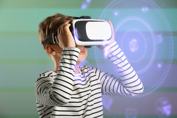 Wall Mural - Cute boy wearing virtual reality glasses on color background